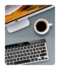 Keyboard on desk with a cup of coffee