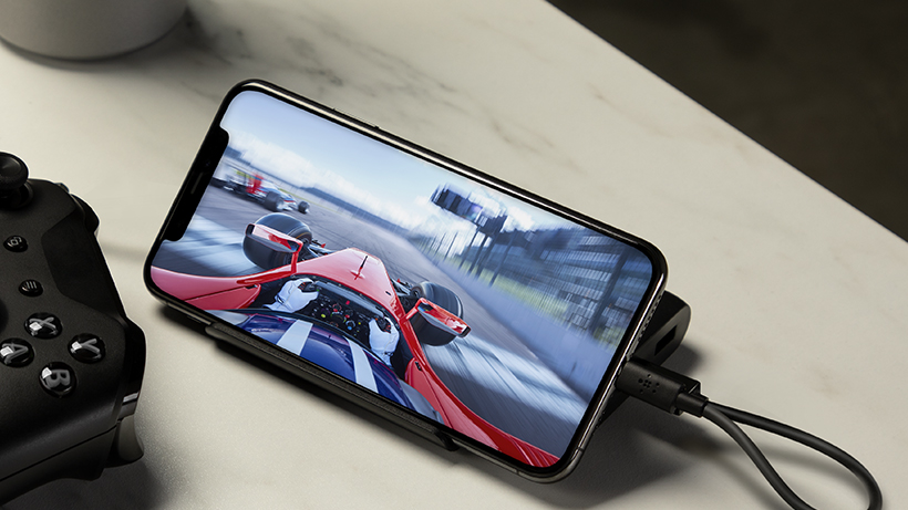 BOOSTCHARGE Power Bank charging a smartphone with a racing game on it