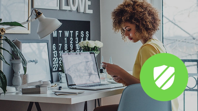 Woman working in a home office with shield icon overlaid