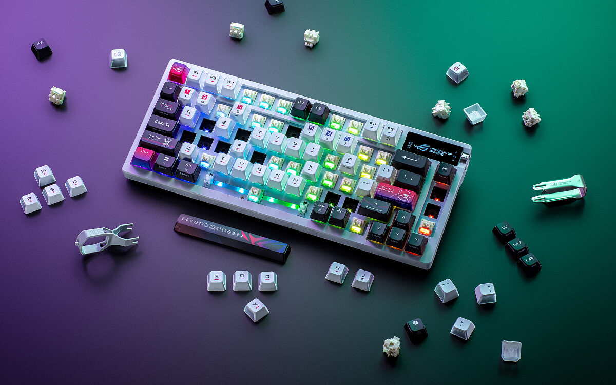ROG Azoth X with many keycaps and switches removed scattered around the keyboard.