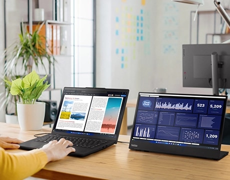 Lenovo ThinkPad L14 Gen 6 (14" AMD) laptop on a desk with a pair of hands on the keyboard and connected to a ThinkVision monitor  right-front view, lid open
